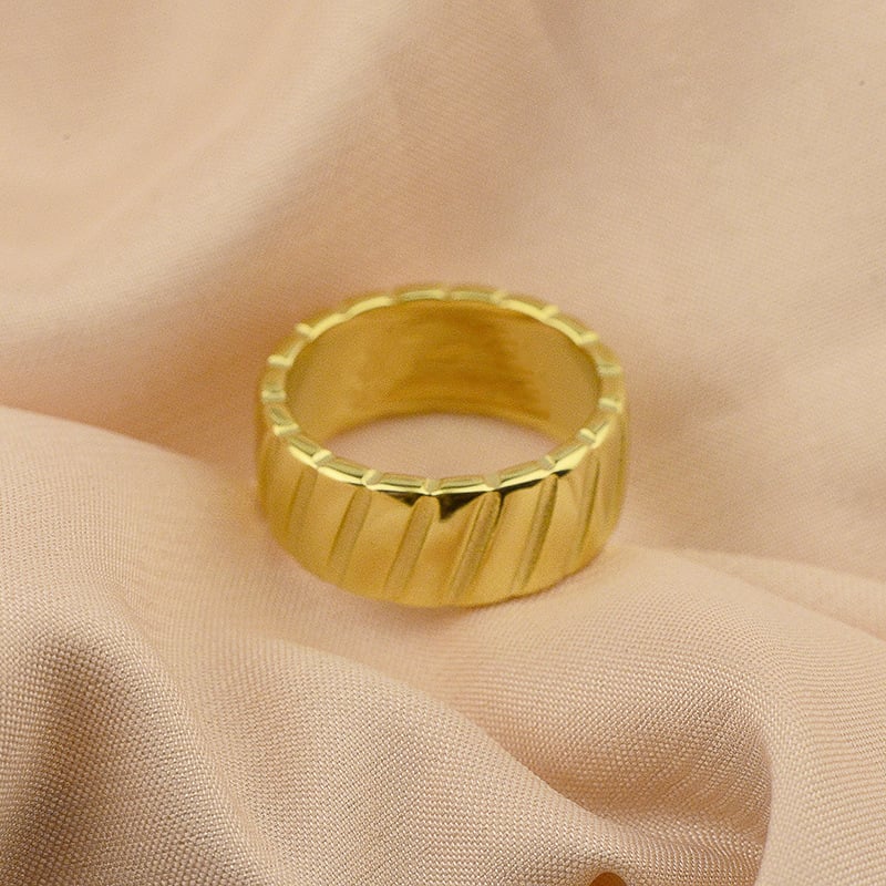 Bague en acier titane avec motif biseauté en or 18 carats, élégante et moderne, vue de face sur un fond neutre