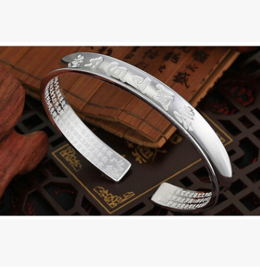 Bracelet en argent plaqué avec un mantra de six caractères, bijou élégant porté au poignet, design épuré et sophistiqué.