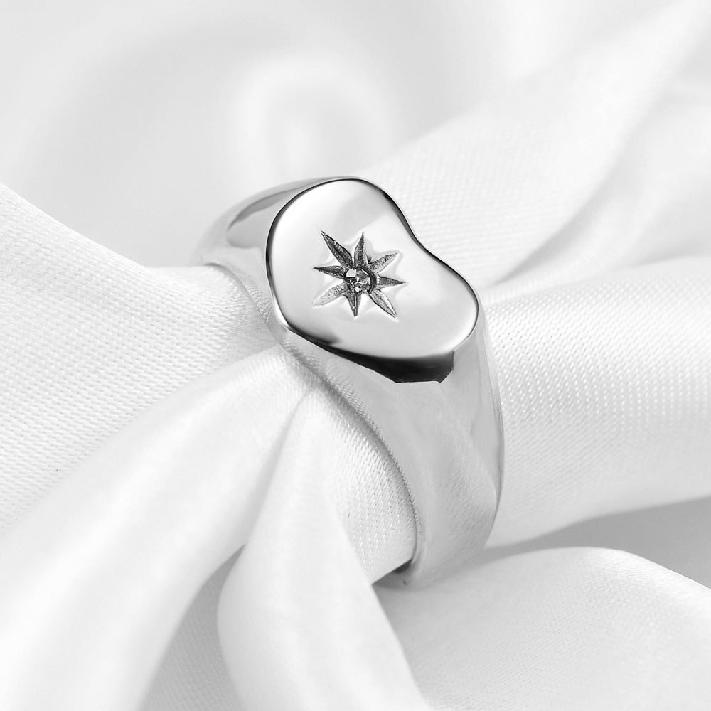Bague en acier titanium plaqué or avec diamant, symbole d'amour, vue en gros plan sur l'anneau brillant.