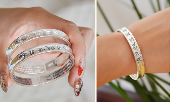 Bracelet en argent plaqué avec six caractères de mantra, design élégant et fin, porté au poignet.