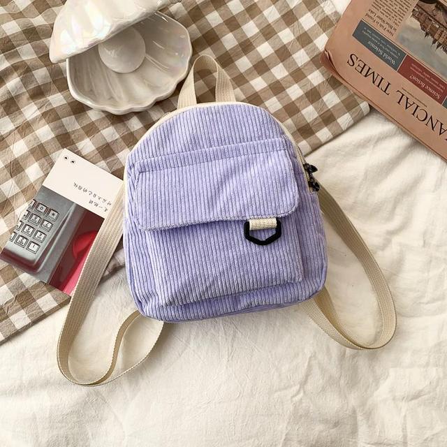 Mini sac à dos en velours côtelé pour femmes de la marque Boutique Angenor, avec poignées et poches extérieures visibles.
