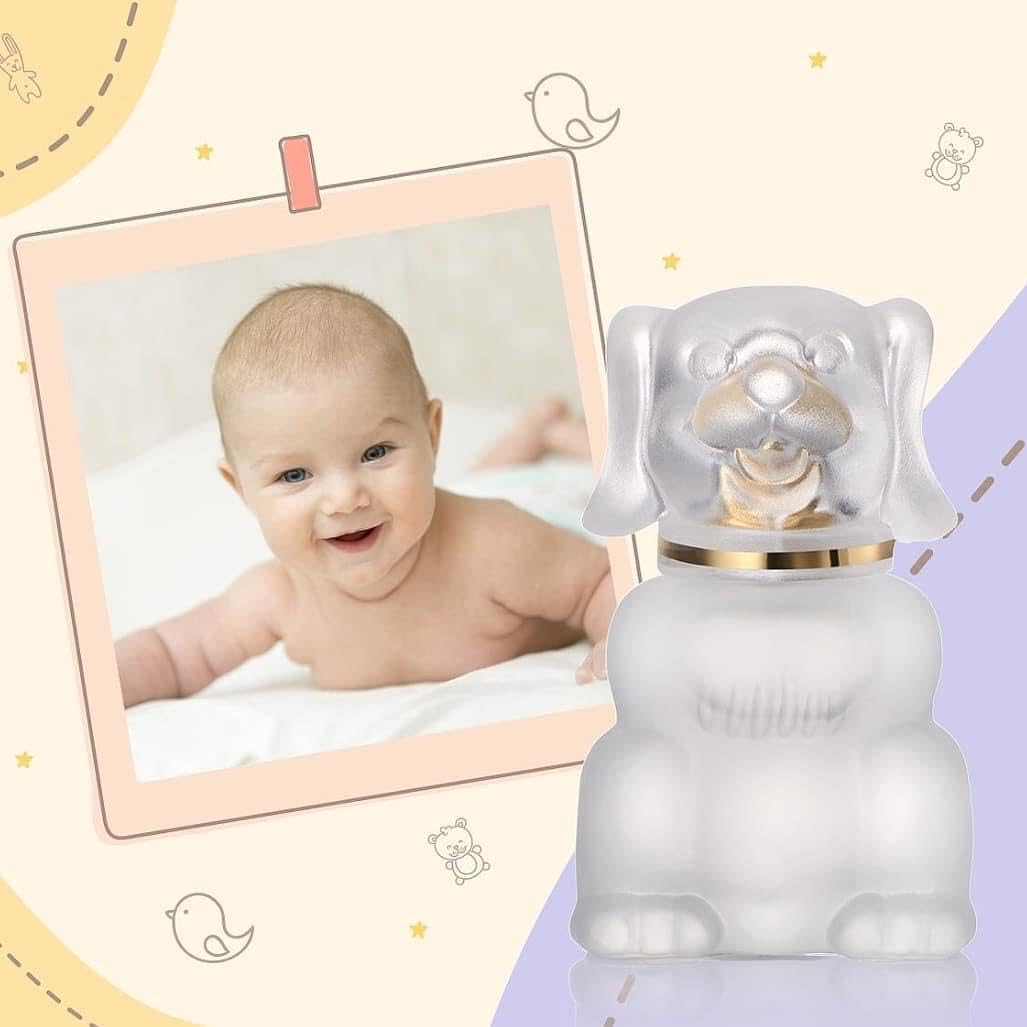 Bébé en tenue unisexe portant du parfum Zermat Baby Boby Cologne de Boutique Angenor, flacon de 2 fl oz visible.