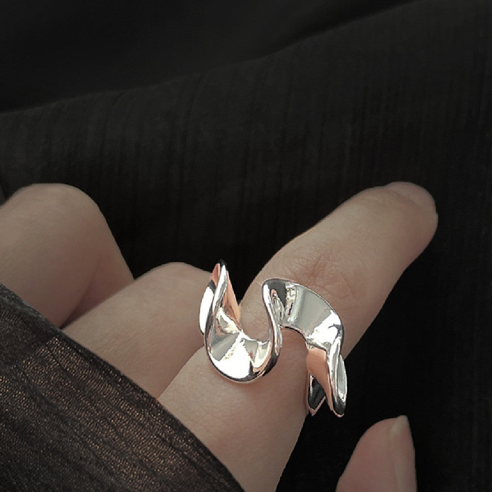 Anneau pour femme sur l'index, design élégant et moderne, en métal brillant, porté sur un doigt.