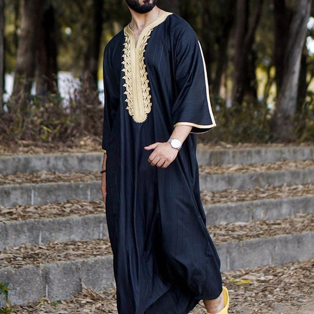 Chemise longue noire pour homme de style musulman, vêtement élégant et confortable, porté par un homme dans une tenue traditionnelle.