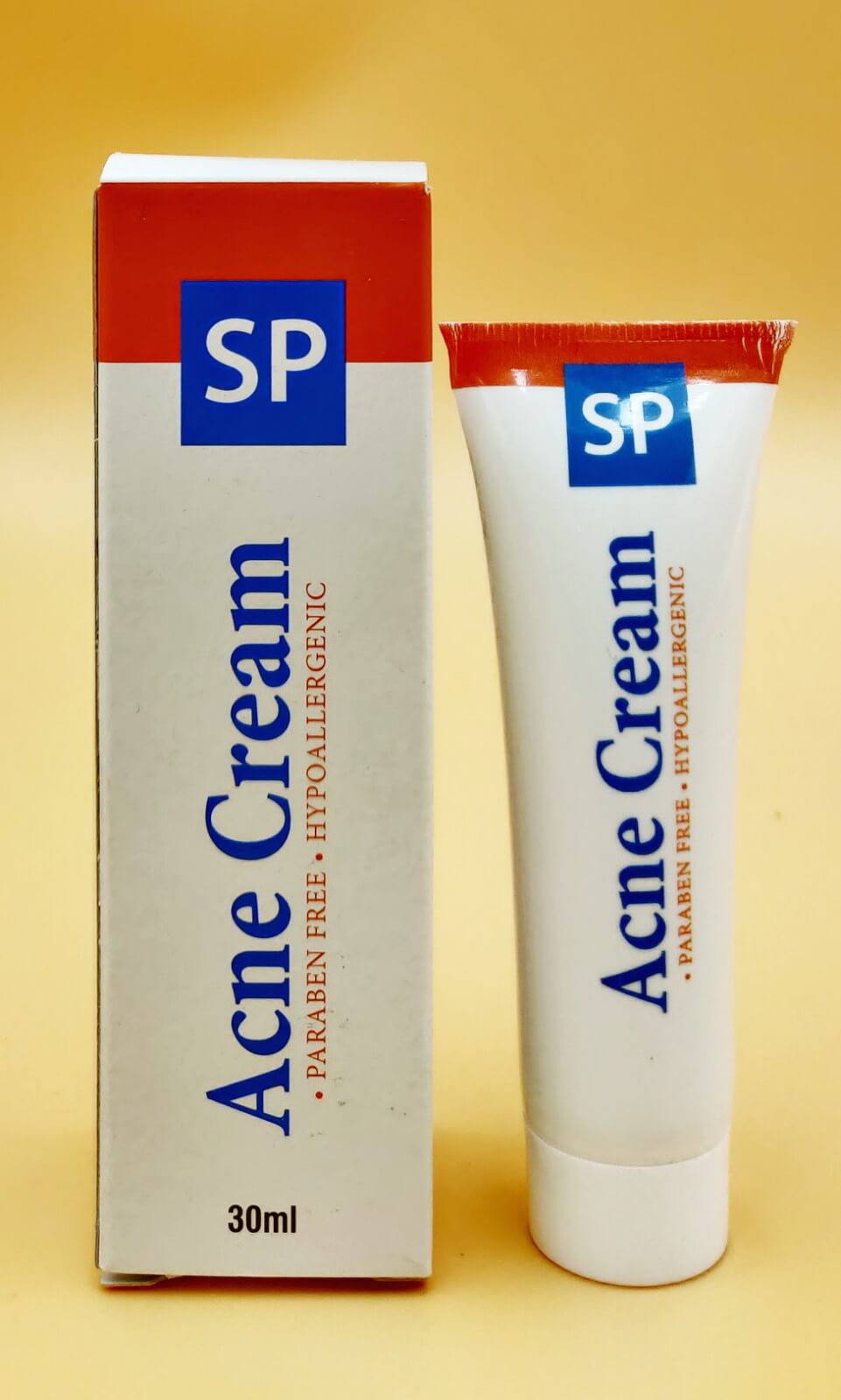 Crème anti-acné Stlouisbeautyline pour soin de l'acné, tube blanc avec étiquette visible, appliquée sur une peau propre.